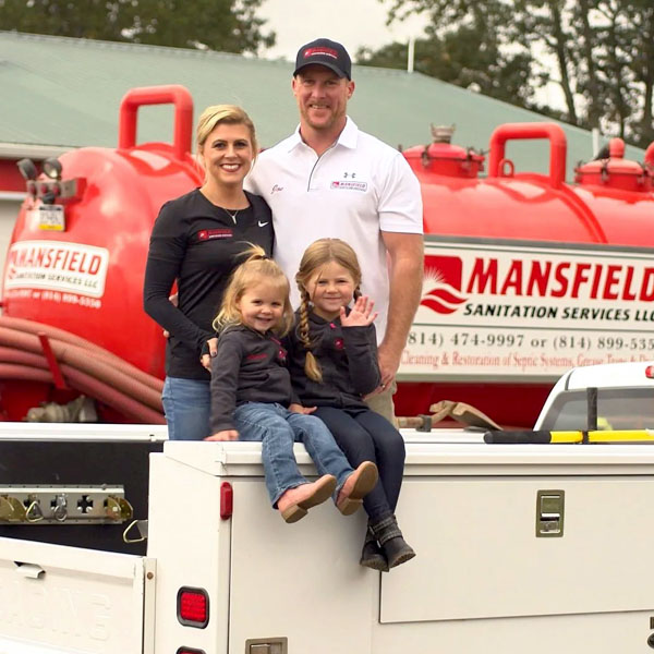 Members of the Mansfiled family sitting on top of a tuck. We are family and veteran owned and operated.