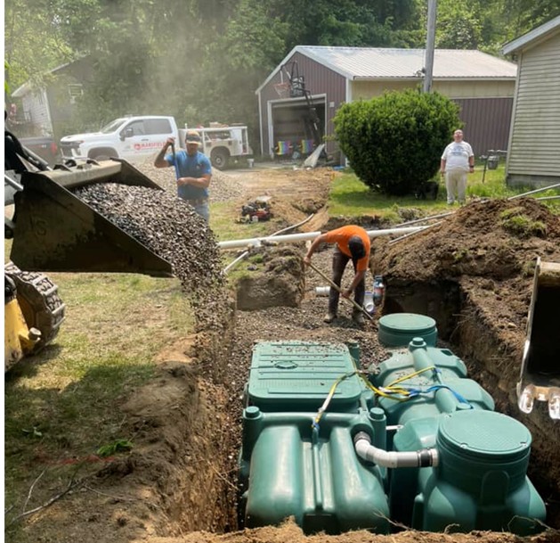 Mansfield Sanitation Services employees installing a septic system.