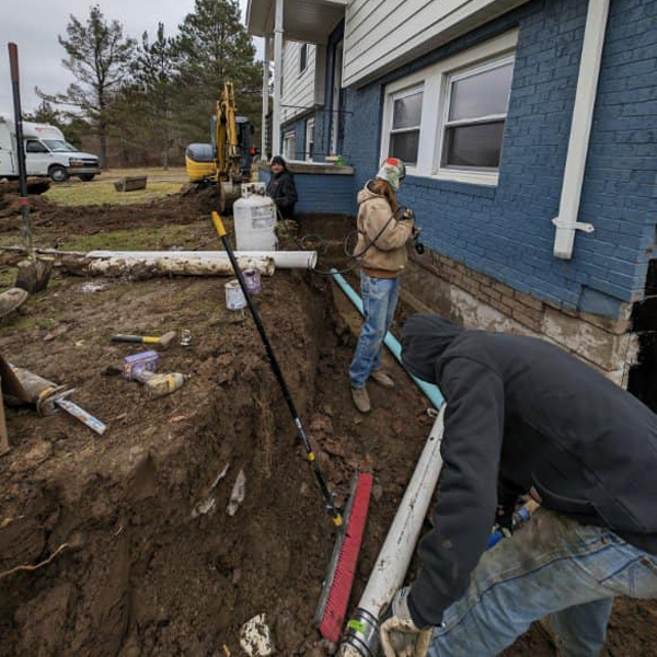 The Mansfield crew installing a drain around the foundation of a house.